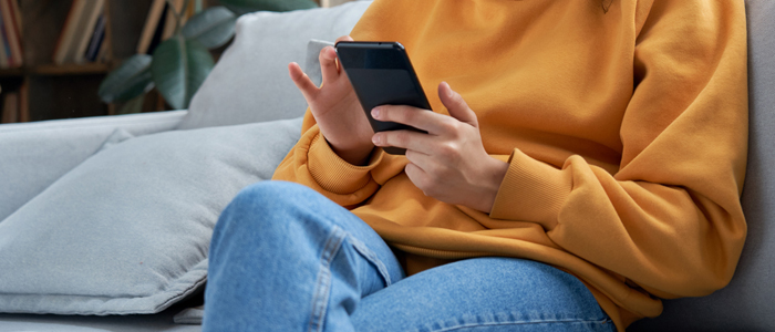 Photo of person on sofa using mobile phone
